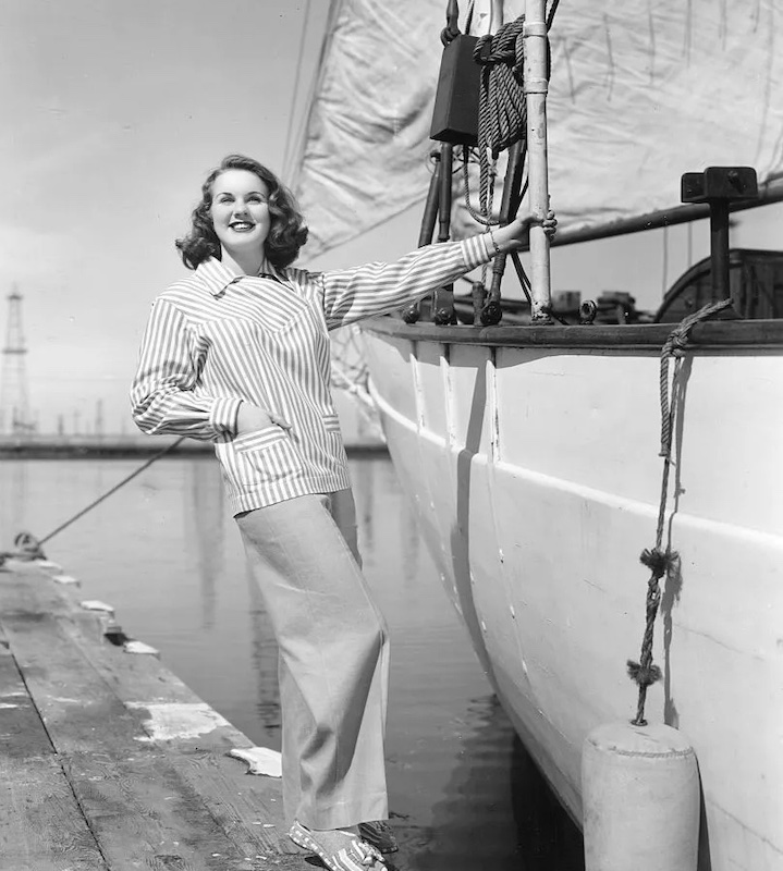 1950 Actress and model Deanna Durbin perfecting a chic sailing look in wide-leg khakis and a striped jacket. #vintagefashion