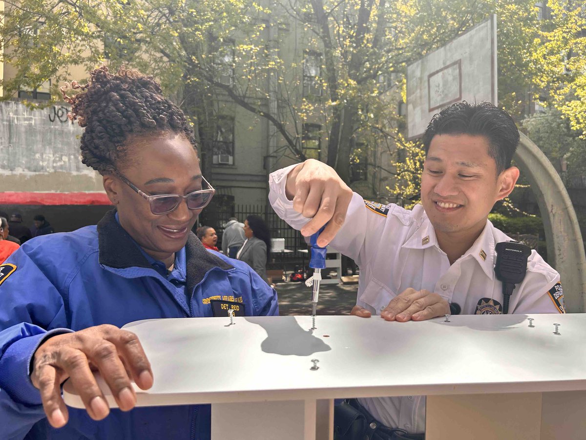 Captain Cheng and Detective Reid join Assembly Member Harvey Epstein in assembling bookshelves for kids at The Earth Day Event, held at the LES II Houses.