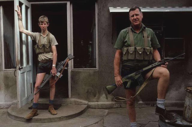 Two armed farmers, father and son, Zimbabwe, 1986.