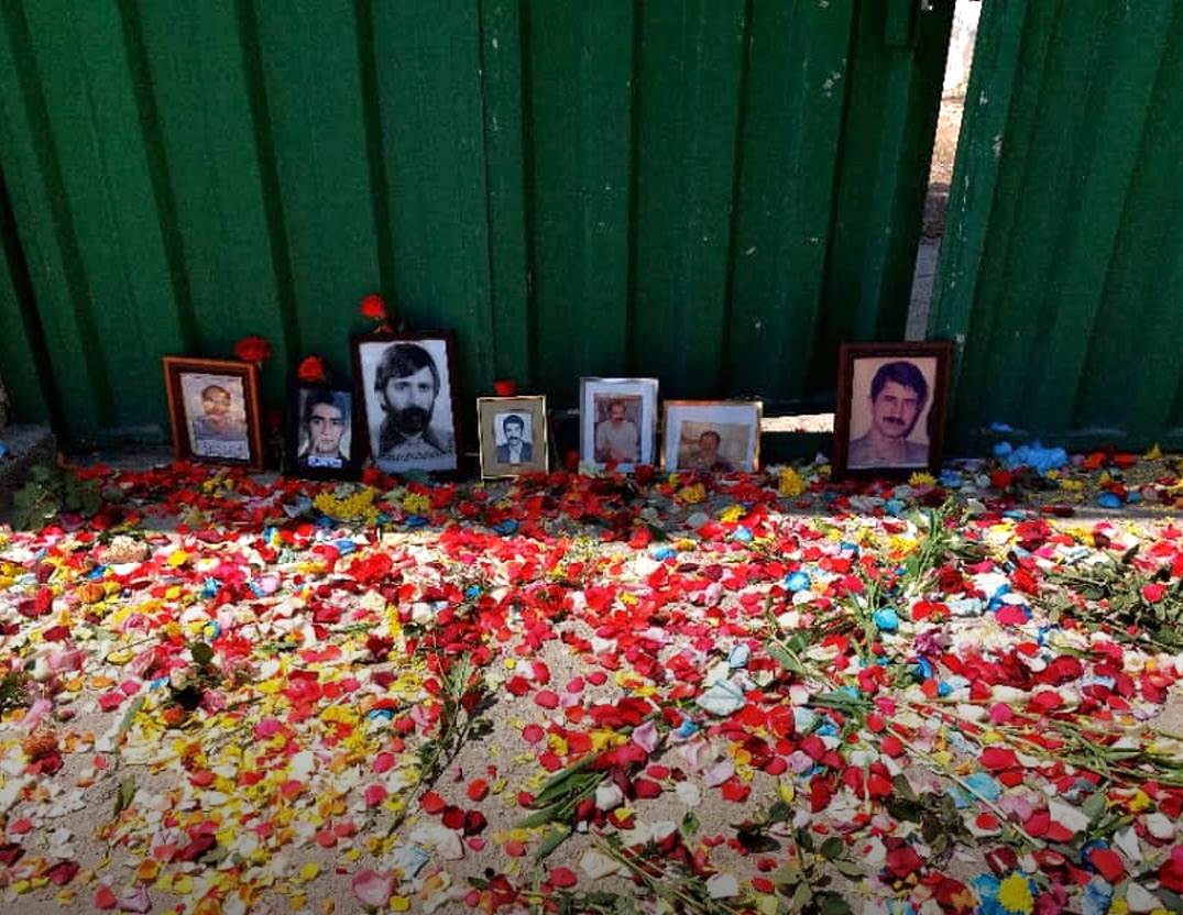 Families of victims of the 1988 political mass executions displayed pictures of their loved ones behind the locked gate of Khavaran Cemetery in Tehran. They were prevented from entering the grounds where their relatives were dumped in mass graves. #Iran #خاوران