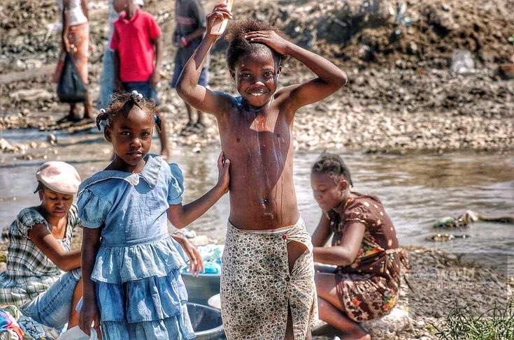 Haitians bathe in a polluted creek. Port-au-Prince, Haiti. Gary Moore photo. Real World Photographs.  #photojournalism #world #haiti #portauprince #environment #poverty #sweden #garymoorephotography #denmark #realworldphotographs #nikon #photography