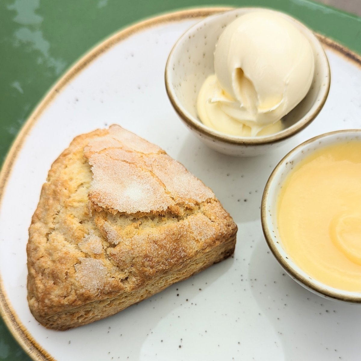 LEMON SCONE 🍋 Have you tried our lemon scone yet, they're made fresh and served with Clotton Creamery clotted cream and our nice and tangy lemon curd. Enjoy eating in or as a take away. Now the real question is, clotted cream or lemon curd first?