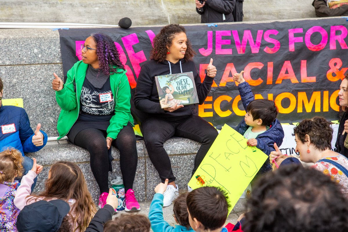 At yesterday’s Kids Seder in the Streets, we gathered for singing & story outside the Brooklyn Public Library. Then we marched through the farmers market singing and chanting until we reached Sen. Schumer’s block, where Brooklyn kids asked him four questions… 📸Noah Levine