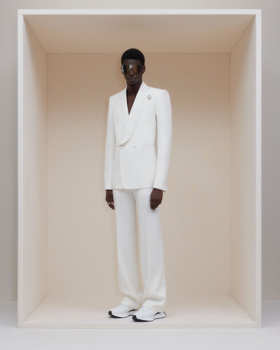 A double-breasted tailored jacket with a half-shawl collar and wide-legged trousers in ivory, paired with silver mask sunglasses. Discover #McQueenMenPreAW24: on.alexandermcqueen.com/PreAW24Mens_TW