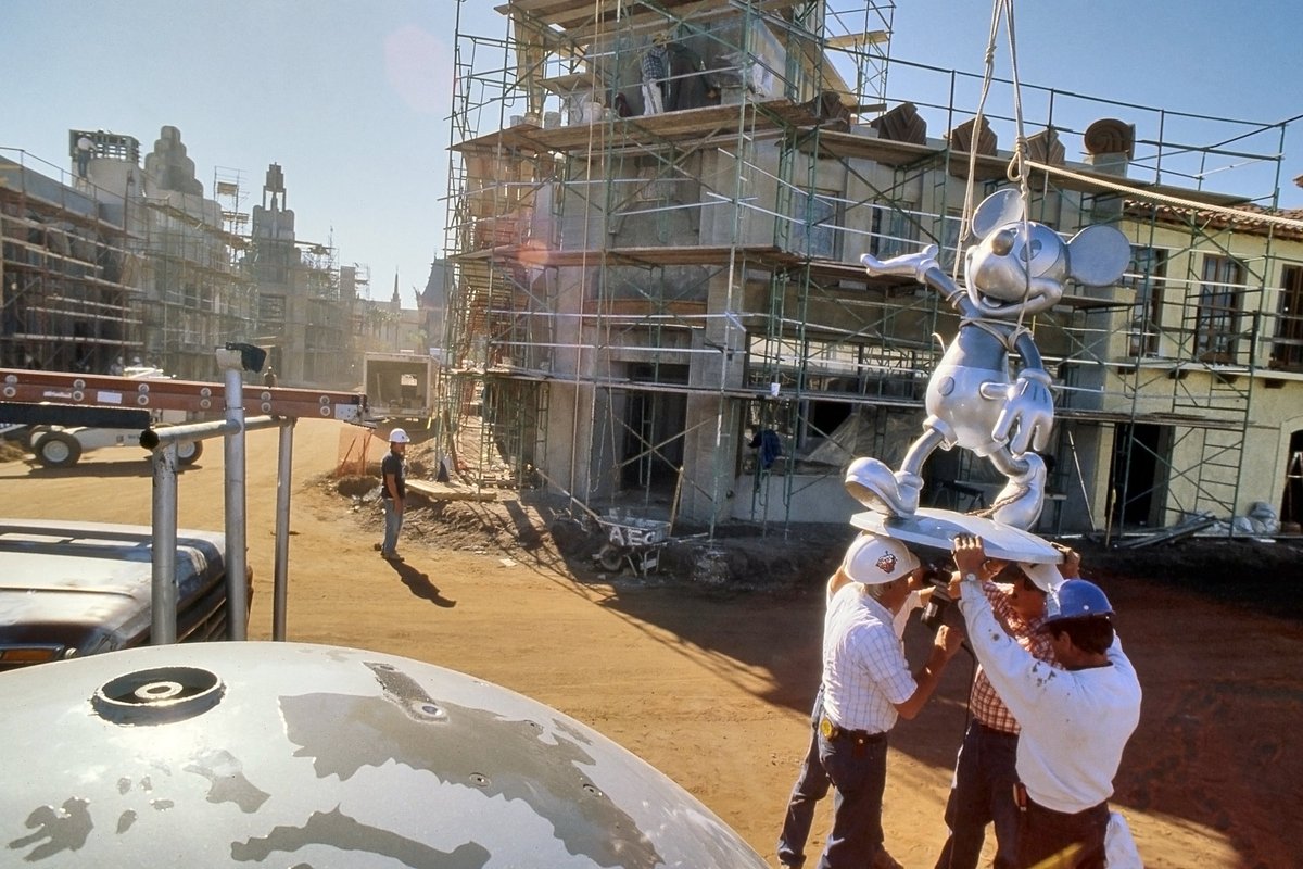 A mono-chrome-matic Mickey is prepped to be hoisted 55' to the top of the Crossroads of the World focal point of Hollywood Blvd. 

He would later be repainted in his traditional colors in a last-minute change to improve visibility from the street below.
#Studios35