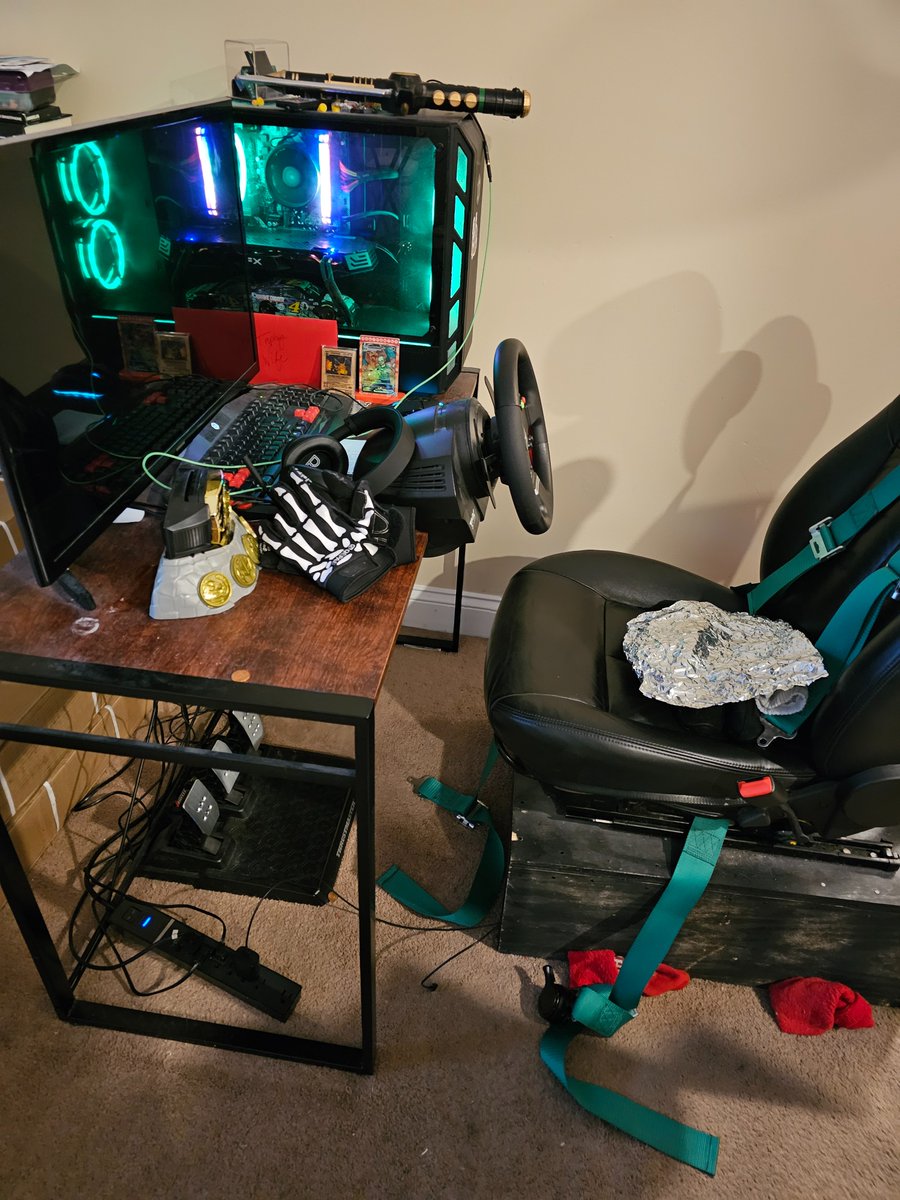 My original iRacing rig has gone into retirement after 900+ official series starts and 25k+ laps. A Thrustmaster TMX, first with the original pedals and later the T-3PAs, clamped to a Staples desk with the seat of out of a Saturn Ion bolted to a wooden box. 

#iRacing #Simracing
