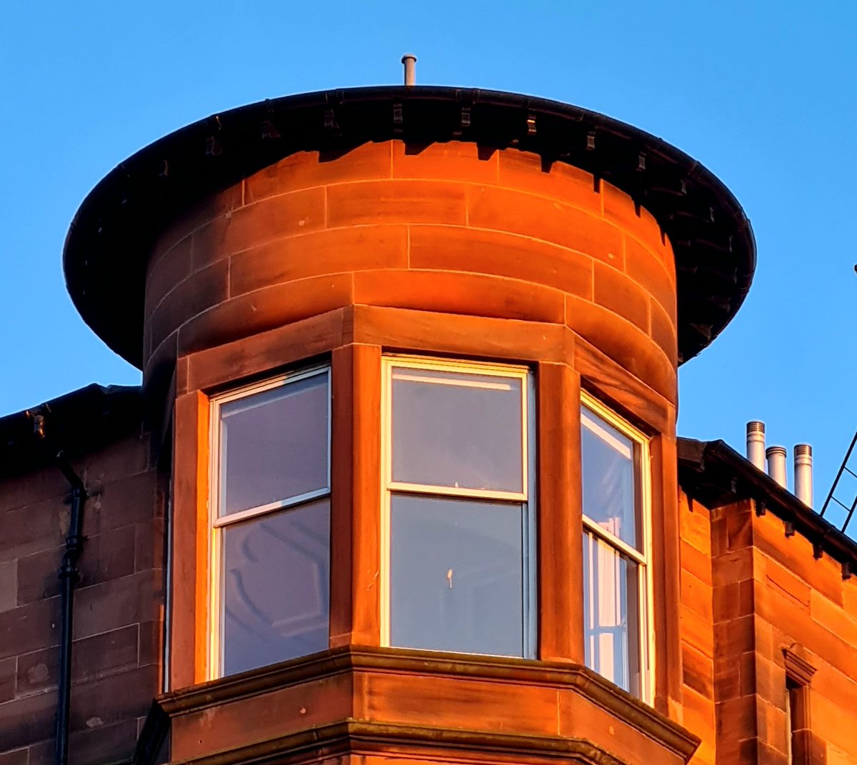 Top floor corner bay window of a red sandstone tenement in the Hyndland area of Glasgow glowing almost blood red in the last rays of tonight's setting sun.

#glasgow #architecture #glasgowbuildings #tenement #glasgowtenement #baywindow #redsandstone #hyndland #windowswednesday