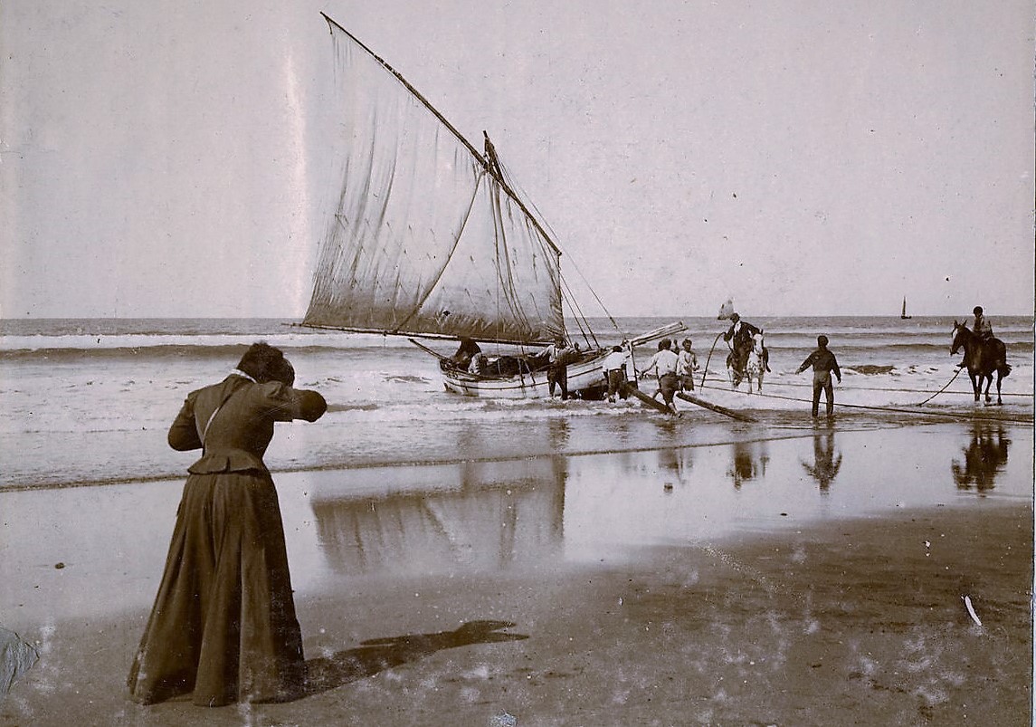 Mujer fotógrafa en Mar del Plata, 1910. Su nombre no quedó registrado pero, sin dudas, fue una precursora. Alguien -cuyo nombre tampoco trascendió- la fotografió mientras registraba la tarea de los pescadores en Playa Bristol. Aporte: Ignacio Iriarte