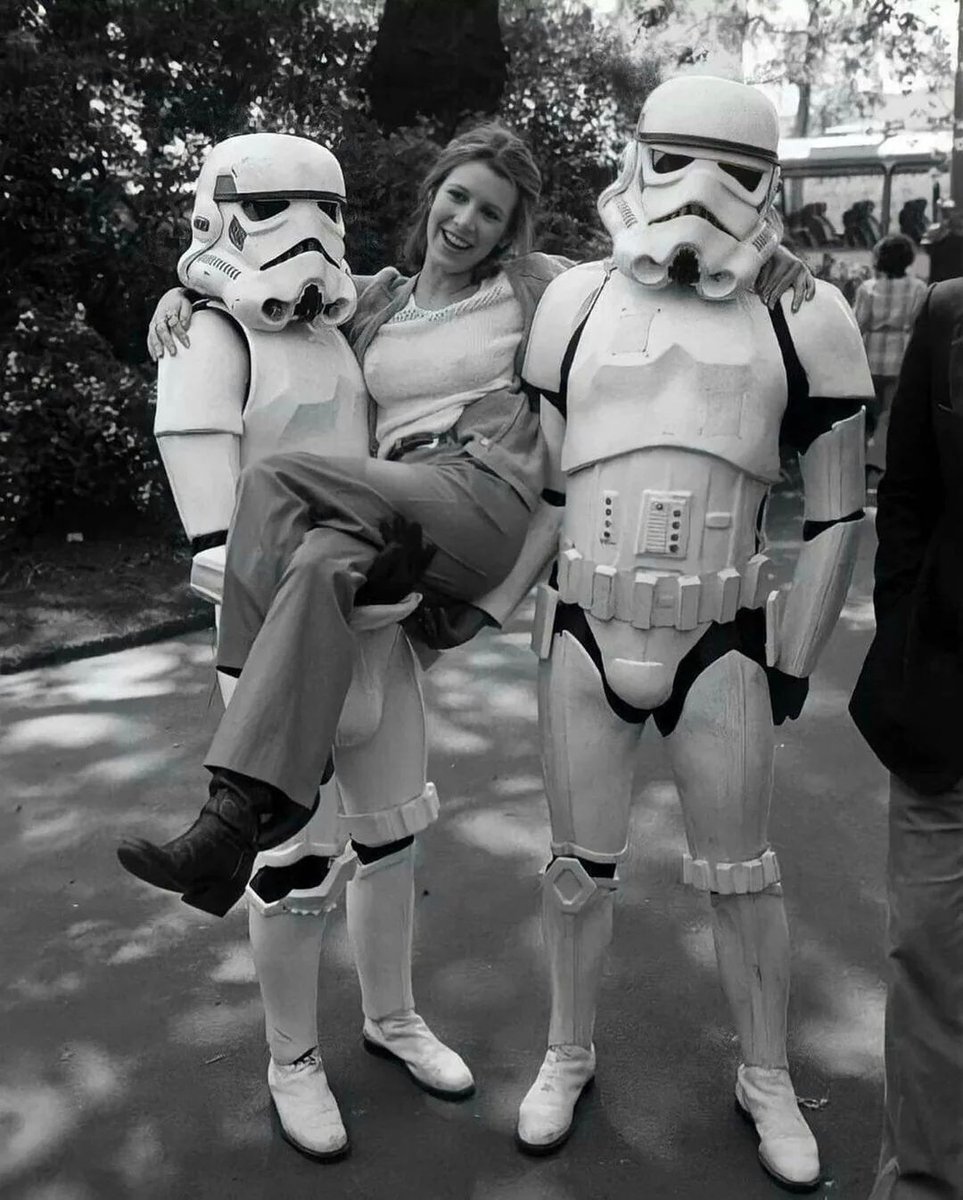Carrie Fisher hanging out with some stormtroopers while promoting “Empire Strikes Back” in London, 1980.