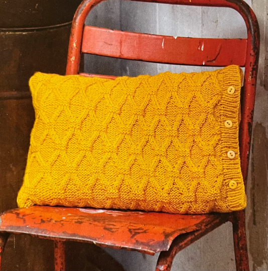 This delightful cable trellis cushion pattern 💛🧡 With its rich lovely texture and charming side buttons, it's the perfect blend of cosy handmade chic for your home. #MHHSBD #craftbizparty #elevenseshour