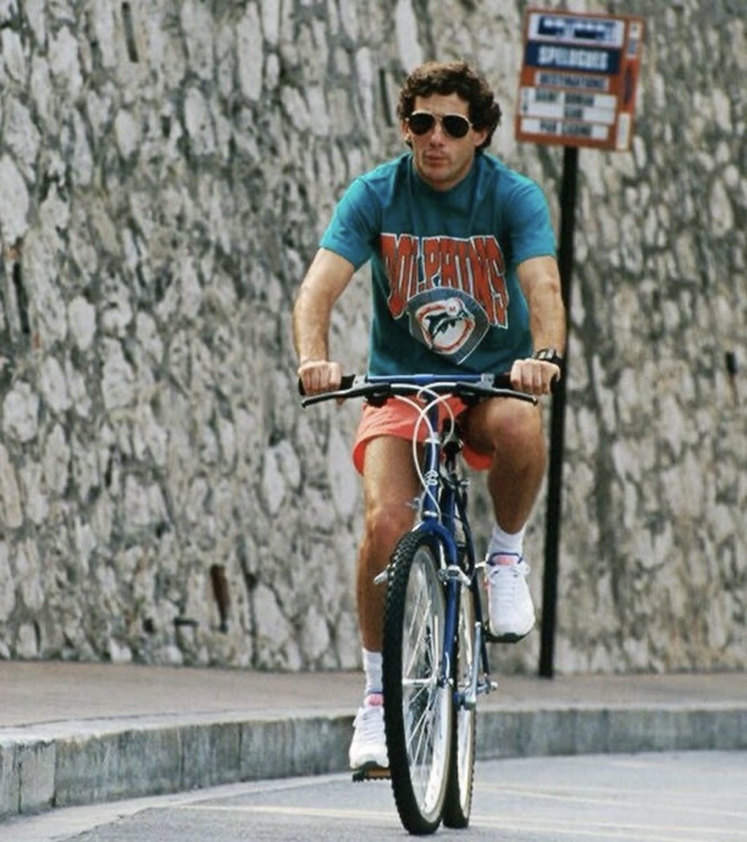 Ayrton Senna riding the streets of Monaco over the 1991 GP weekend wearing a Miami Dolphins t-shirt by Starter and original Nike Air Max 180 Ultramarine sneakers. #MiamiGP