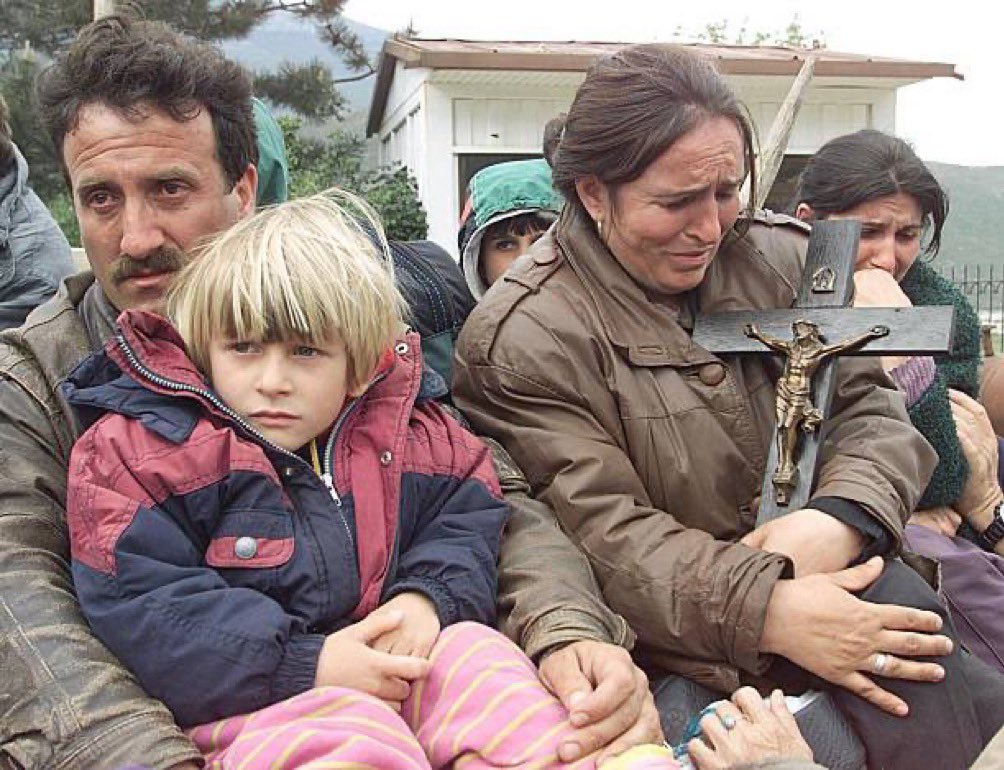 Albanian catholic refugee from Kosovo holds a crucifix shortly after arriving at Morina border checkpoint.Several thousand more Kosovo Albanian refugees arrived here today,alleging Serbian atrocities. 28 April ‘99. 𝘗𝘩𝘰𝘵𝘰&𝘊𝘢𝘱𝘵𝘪𝘰𝘯 𝘣𝘺 𝘊𝘏𝘙𝘐𝘚𝘛𝘖𝘗𝘏𝘌 𝘚𝘐𝘔𝘖𝘕