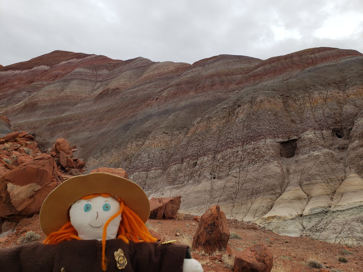 Ranger Sarah with another color mountain view. The purple and white colors are caused by the presence of manganese oxides and gypsum, respectively. — at Grand Staircase-Escalante National Monument. #adventuresofrangersarah #rangersarah #grandstaircaseescalante #utah #geology