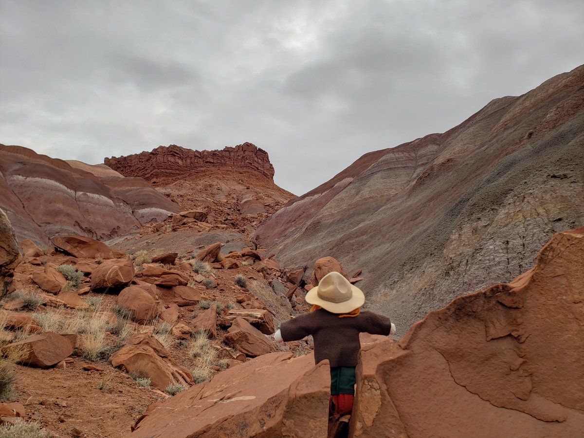 Ranger Sarah stands on a large boulder to take in the view of the mountain above. —Grand Staircase-Escalante National Monument. #adventuresofrangersarah #rangersarah #grandstaircaseescalante #utah #outdooradventures #geology #geologyrocks #explore #hike #hikingadventures #hiking