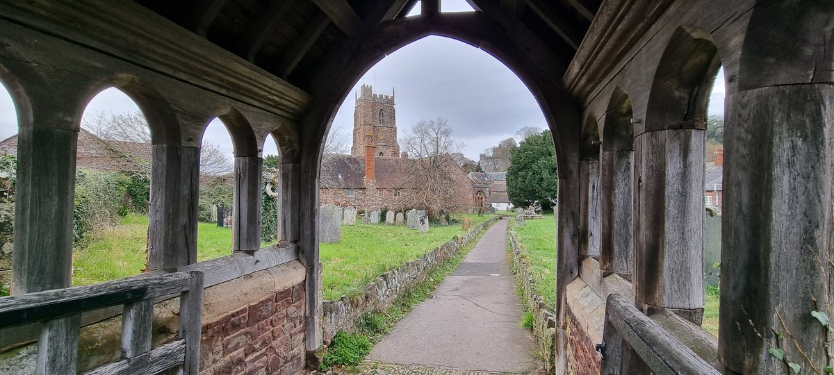 Glimpsing towards the timeless beauty of Dunster's Priory of St. George Church through the tranquil graveyard. #Dunster #DunsterInfo #DunsterVillage