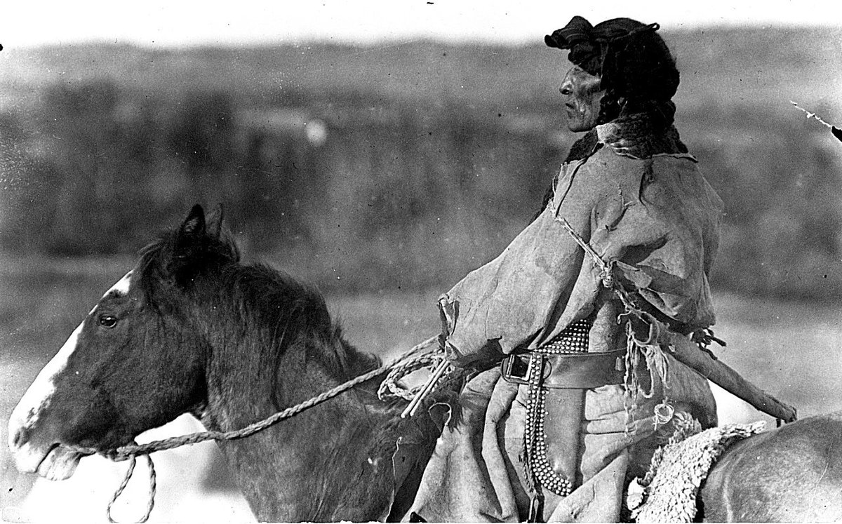 Portrait (profile) of an unidentified man, possibly a member of the Crow Indian tribe, on horseback. - 1910s