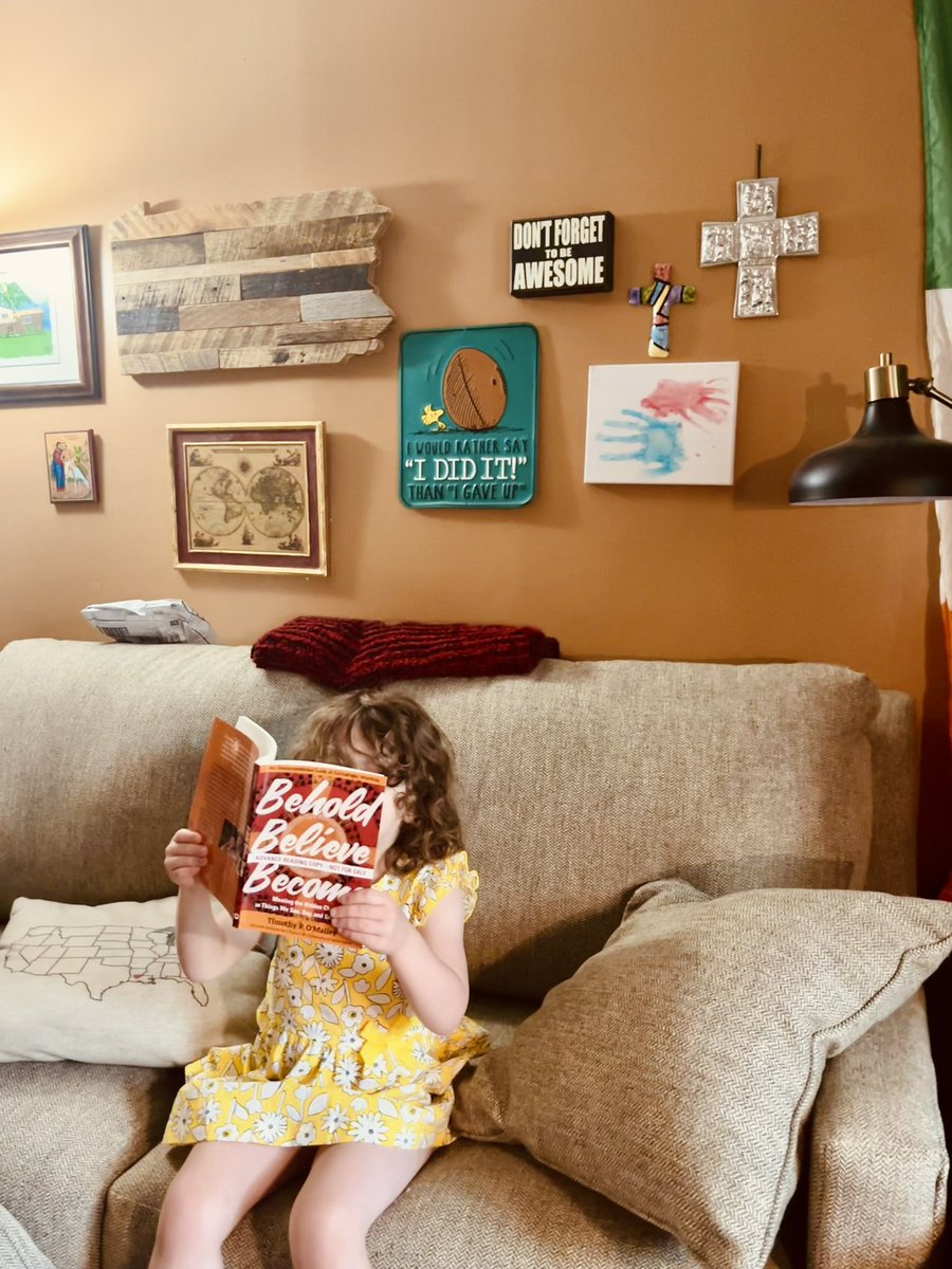 I promise you this was not staged (as evidenced by the unopened Target package on top of the couch). Clare just really loves @timothypomalley’s new book from @avemariapress avemariapress.com/products/behol…