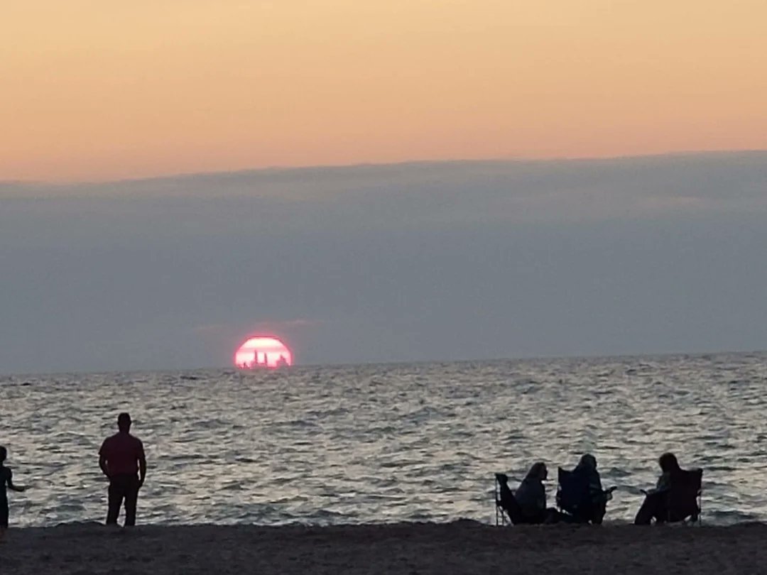 Chicago skyline visible from nearly 50 miles away in Indiana Dunes sunset.