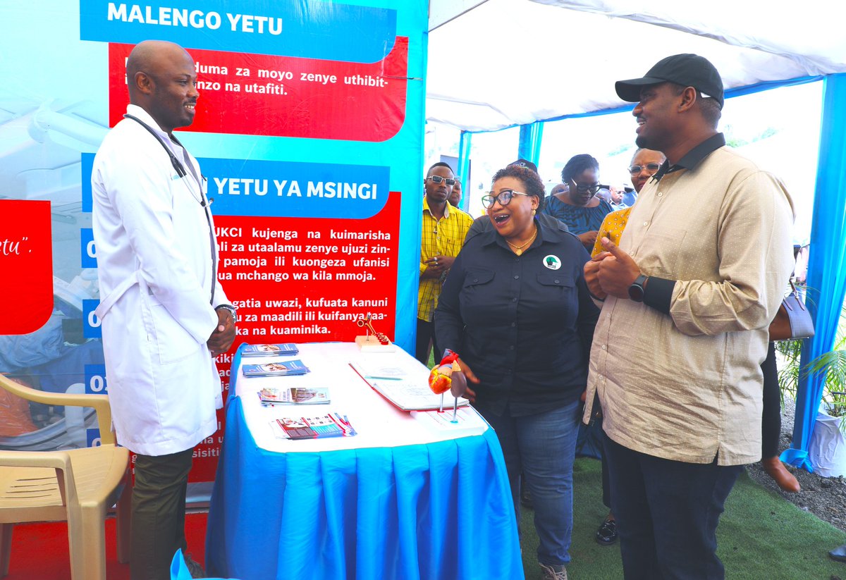 Waziri wa Nchi Ofisi ya Waziri Mkuu Kazi Ajira Vijana na Wenye Ulemavu Mhe. Deogratius Ndejembi akizungumza na Daktari bingwa wa moyo wa JKCI Dickson Minja alipotembelea banda la Taasisi hiyo wakati wa maonesho ya kimataifa ya usalama na afya mahali pa kazi jijini Arusha.