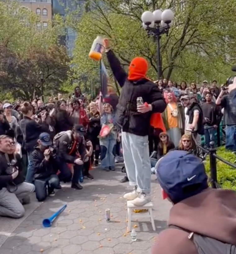 Hundreds gathered in NYC to watch a masked man eat a gigantic jar of cheese balls