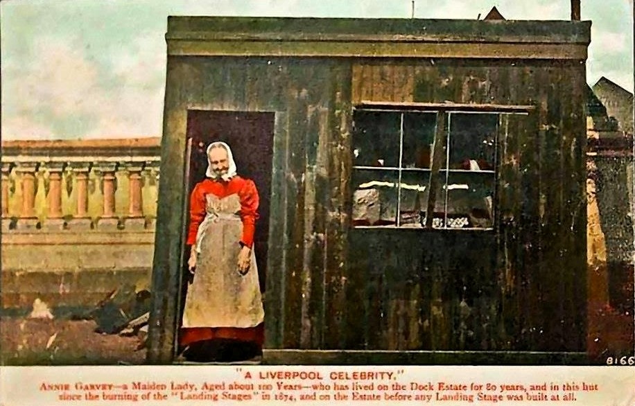 Annie Garvey 'the maid of thePier Head', Liverpool. Aged about 100 years old on this photograph. (c1906), Annie fled the Great Famine in Ireland during the 1840's. Annie sold bread, marbles, matches and toffees from her home-which was this tiny hut at the Pier Head.