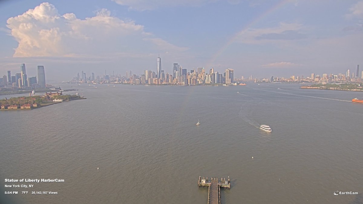 A rainbow can be seen in the NY Harbor with showers and a few thunderstorms in the area! If you look closely, the rainbow is actually extending all the way to the bottom of the picture, indicating that this is happening right in front of the camera and not in the distance! #NYwx