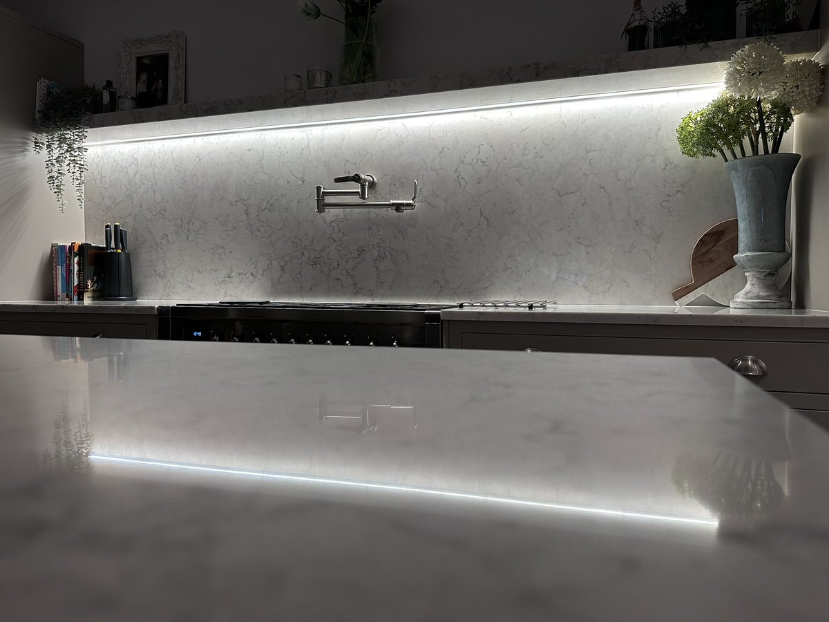 Quartz worktop complete with matching cladding and thick shelf. We’ve added soft  ambient mood lighting using LED channelled under the shelf discreetly. Little energy is used yet makes quite a big impact in design. 

#perrinandrowe #smeg 
#mydreamkitchen #InFramekitchens