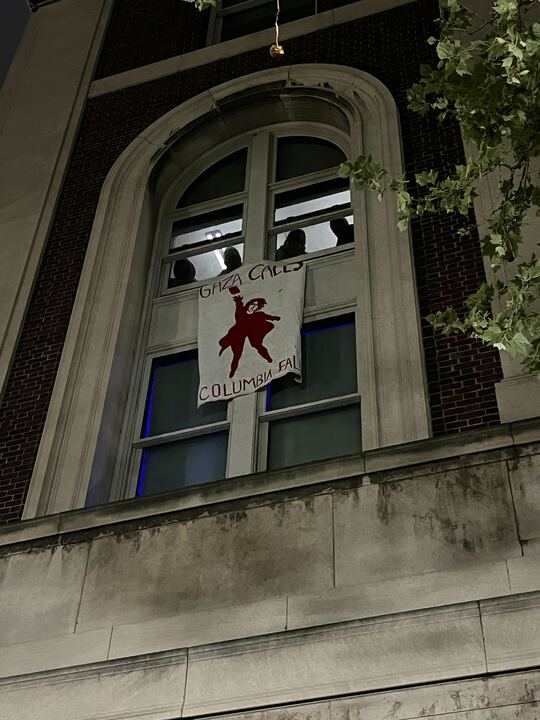 Pro-Palestine posters are being hung from the windows of Hamilton Hall.