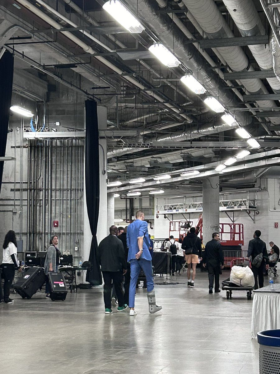 Kristaps Porzingis heading out of the Kaseya Center with a walking boot on his right foot