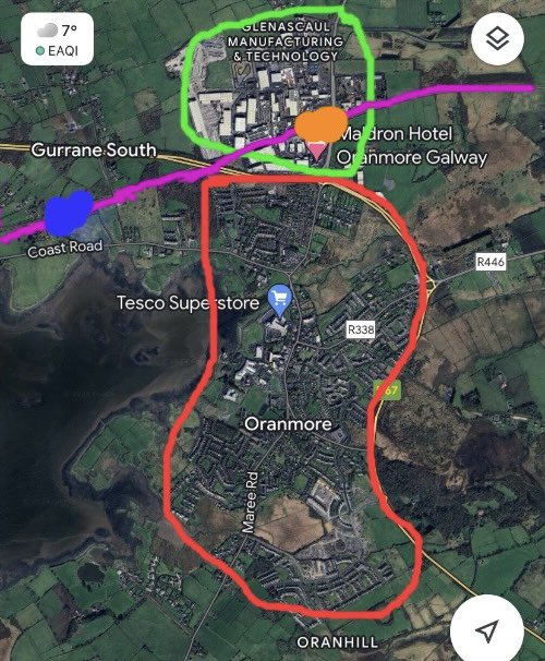 Can someone explain to me why Oranmore Station (blue) - opened in 2013 - was located so far from the town of Oranmore (red), when there is space next to where the old 1851-1963 station was (orange) within a more conveniently located industrial/business area with a hotel (green)?