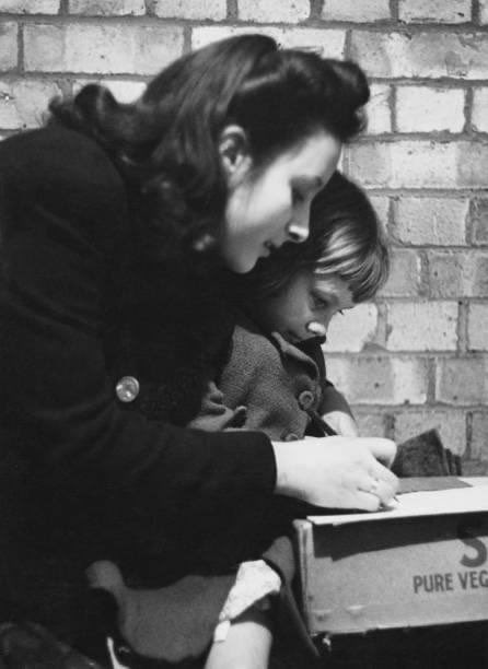 A photograph of mother and daughter  in'Mickey's Shelter', an improvised air-raid shelter in the vaults under the Fruit and Wool Exchange in Brushfield Street, Spitalfields, London, taken in 1941.