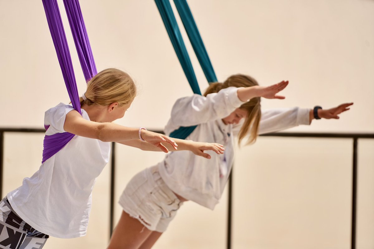 ISDakar's tweet photo. With panoramic views of the glistening Atlantic ocean and a warm breeze, aerial yoga is one of our most engaging enrichment class activities. Our students learn flexibility, yoga, pilates and dance skills all in one. #ISDakar #Yoga #AerialYoga https://t.co/dTTs1N1NNY