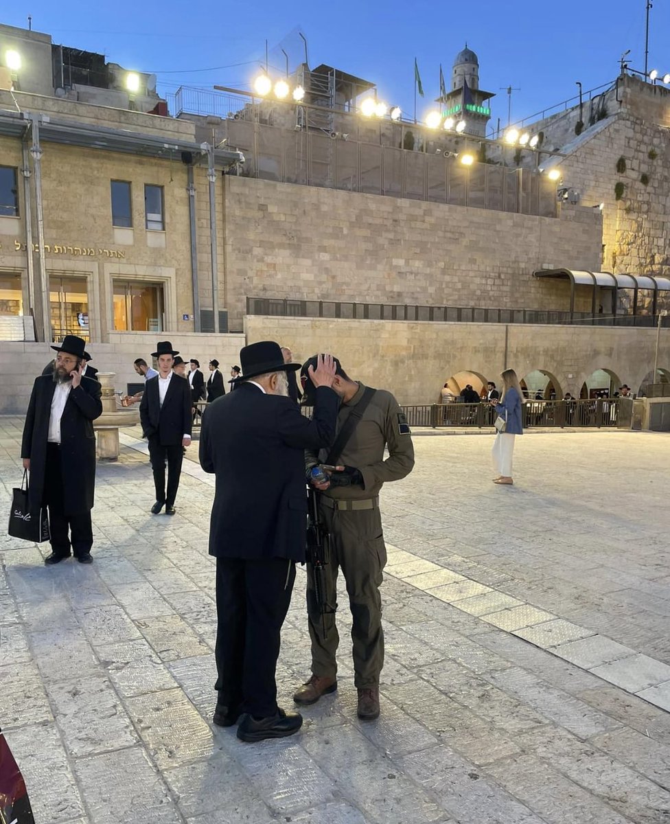 Short time ago a Jew in the centre of the picture with black suit & hat saw a soldier leaving the Kotel - Western Wall. He called out to him as he walked by and asked if he was going to battle? The soldier replied yes. The man said “I have to give you a blessing.” עם ישראל חי