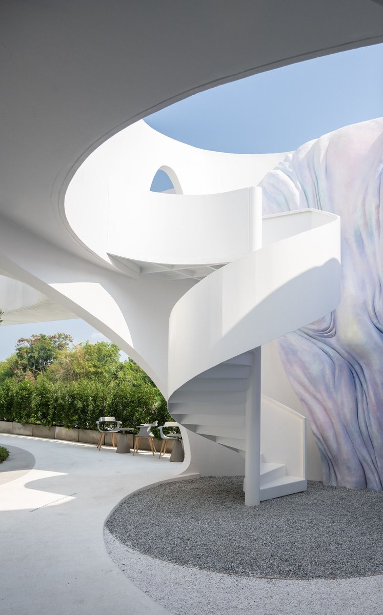 uncloud coffee's arching white structure integrates smoothly into its surroundings in thailand buff.ly/3UByv2m