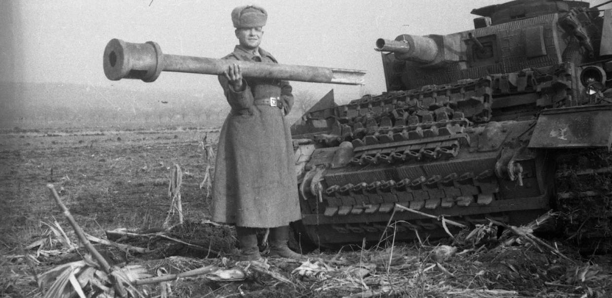 Un soldat soviétique pose avec le canon factice d'un Pz.Beob.Wg.III, un char d'observation pour l'artillerie, perdu au combat en Hongrie en décembre 1944.