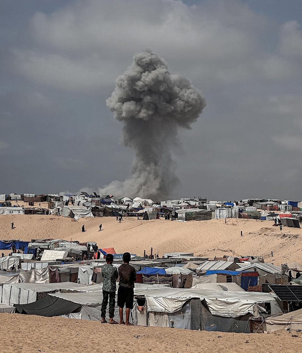 En une image, tout le courage d’un peuple, toute la barbarie de son bourreau.

L’armée israélienne écrase sous les bombes un camp de réfugiés à Rafah. Non loin là, deux adolescents palestiniens regardent le champignon de fumée. Ils ne fuient pas, ils sont debout face à l’horreur.