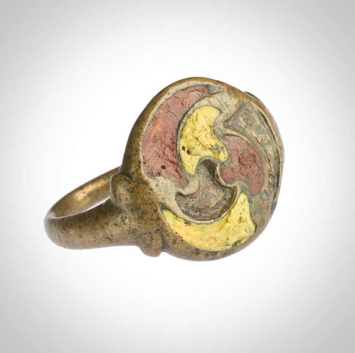 Beautiful bronze finger ring from Tarnavie, Dunning, Perthshire, dates to AD80-200. The ring has a flat round bezel featuring a triquetra framed by another triquetra. It's Inlaid with enamel in yellow, red and a missing colour.  Part of National Museums of Scotland collection.