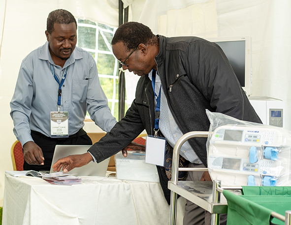 CHAK National Health Care Services (NHCTS) workshop staff Julius Nkandika explains to a guest how to access services from the unit. The workshop offers specialized anesthesia and x-ray machine maintenance services, including calibration and dosimetry. chak.or.ke