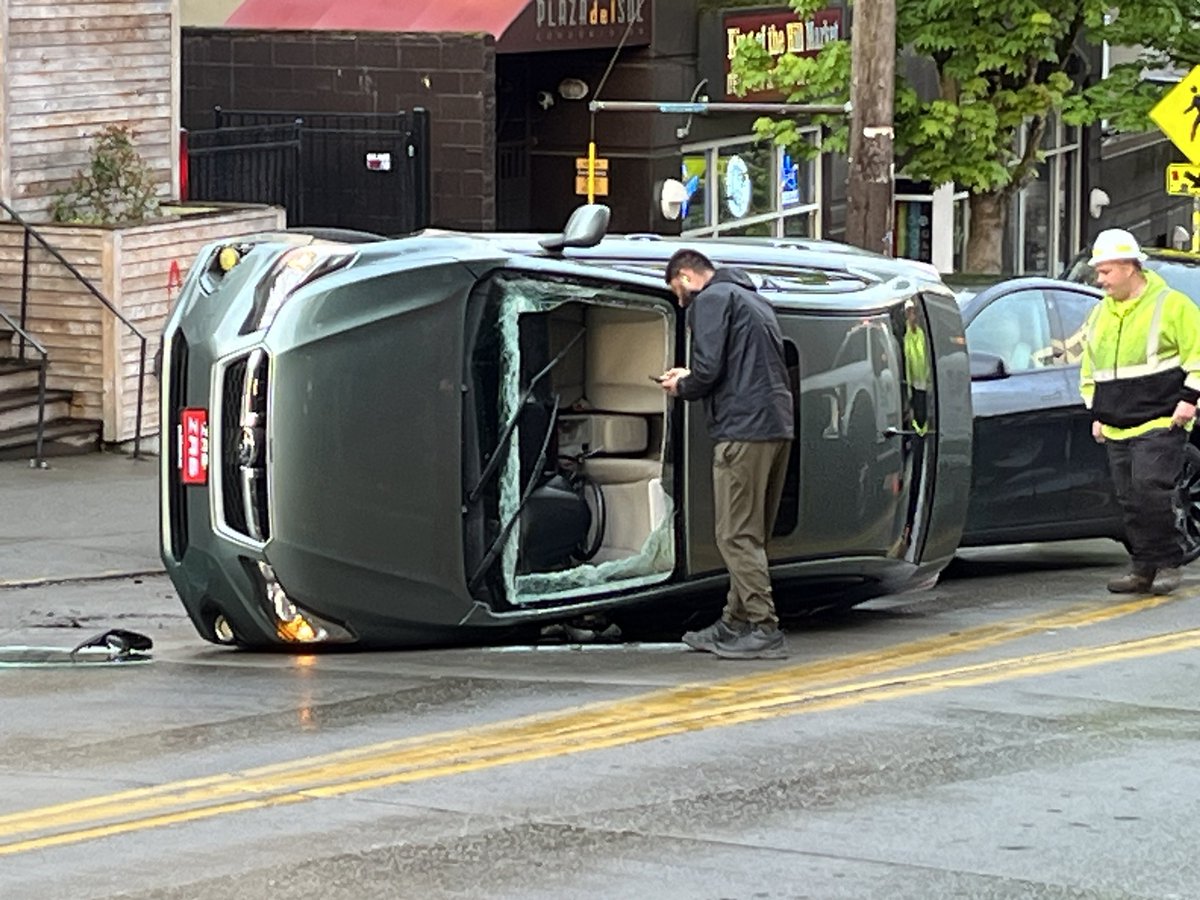 I am not sure how the car got on its side but somehow it managed. This was on E. Olive Way right before Harvard blocking both directions of traffic. Parallel parking gone wrong?