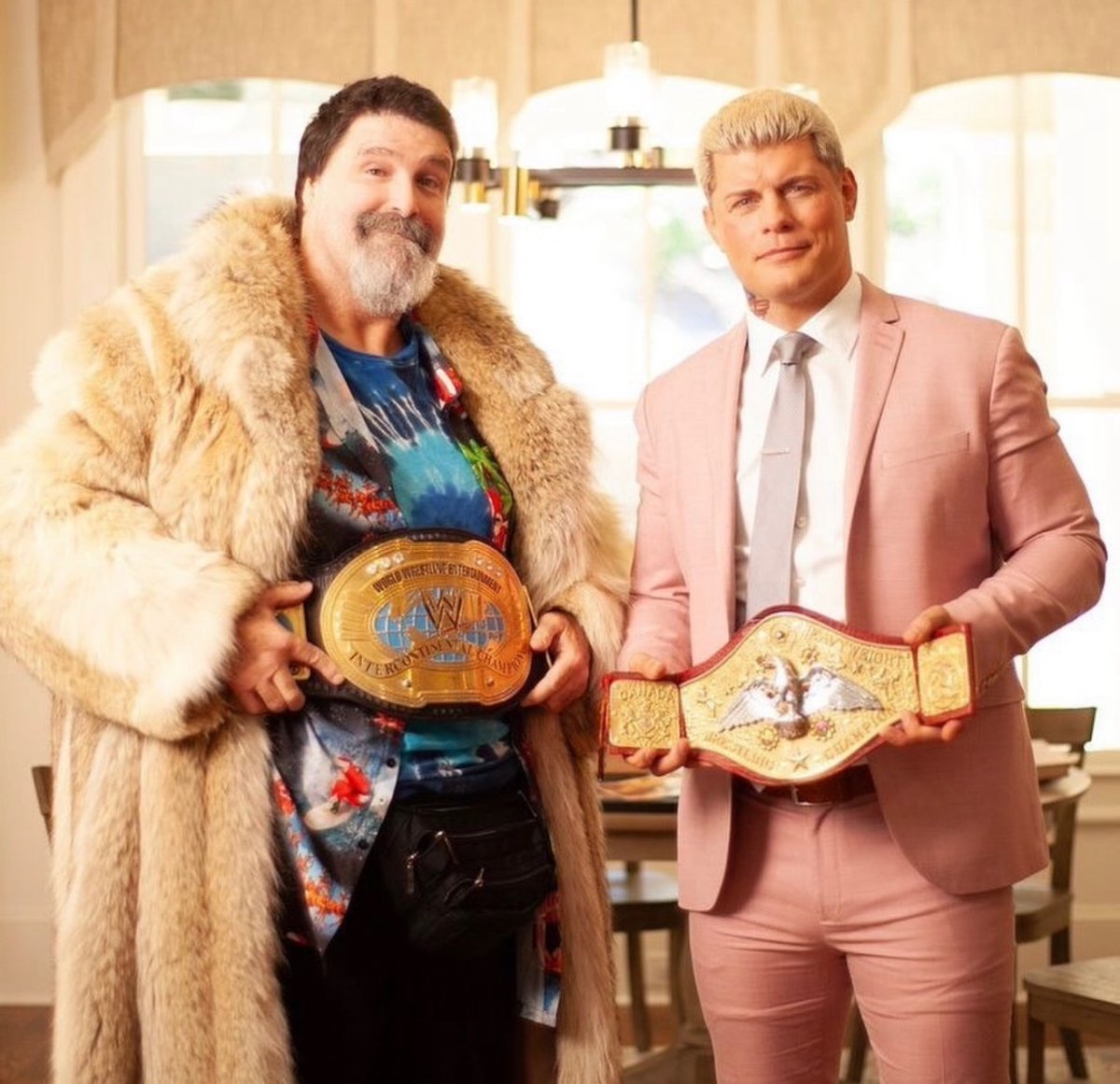 Mick Foley posing with Cody Rhodes and wearing Dusty Rhodes’ famous fur coat