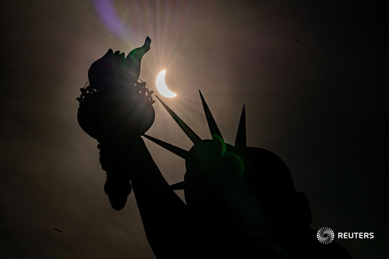 The Statue of Liberty is silhouetted during a partial solar eclipse, where the moon partially blocks out the sun, at Liberty Island in New York City. More photos of the month: reut.rs/3xYFGcd 📷 @NY_PHOTOGRAPHER