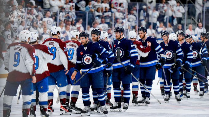 The Colorado Avalanche and Winnipeg Jets shaking hands after the game.