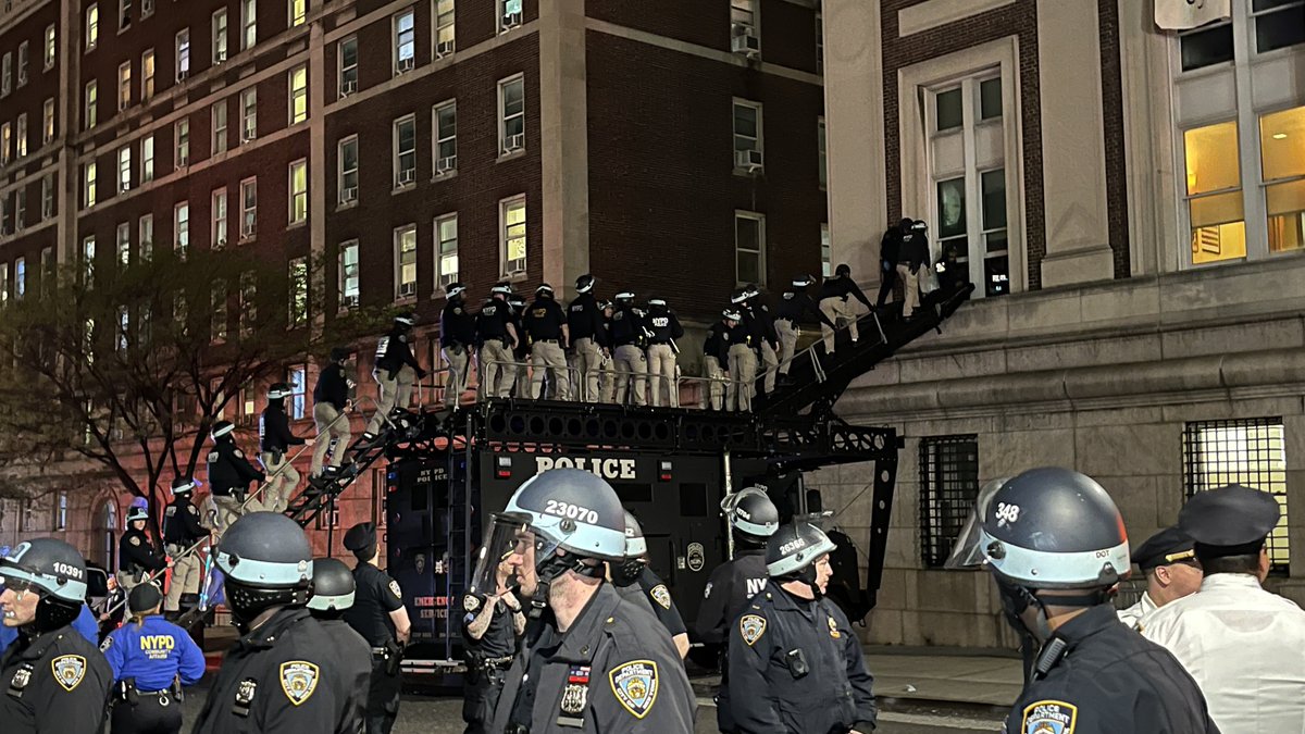 A line of NYPD police officer is waiting to enter the second floor of Columbia University's occupied Hamilton Hall.