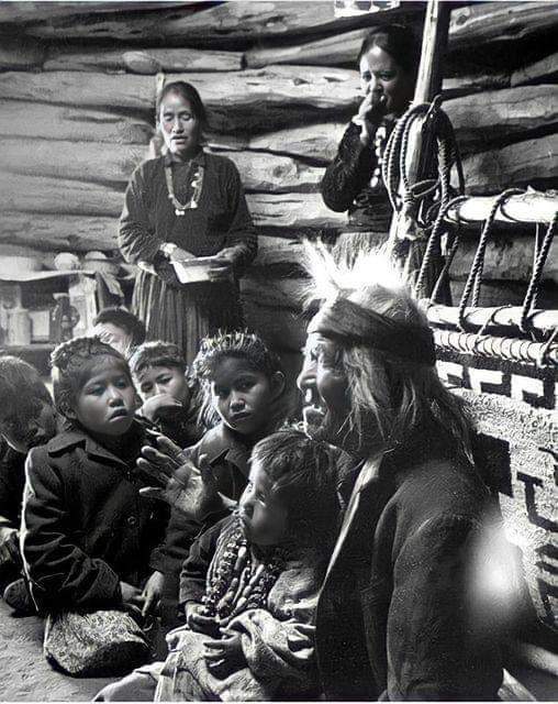 Seated close to the evening fire, 91-year old Navajo man, Gray Mountain, tells small children legends about the early days of the Navajo people. 1948. Photographed by, Leonard James McCombe, Photojournalist. (born June 1st, 1923, on the Isle of Man, and who passed away in 2015.).