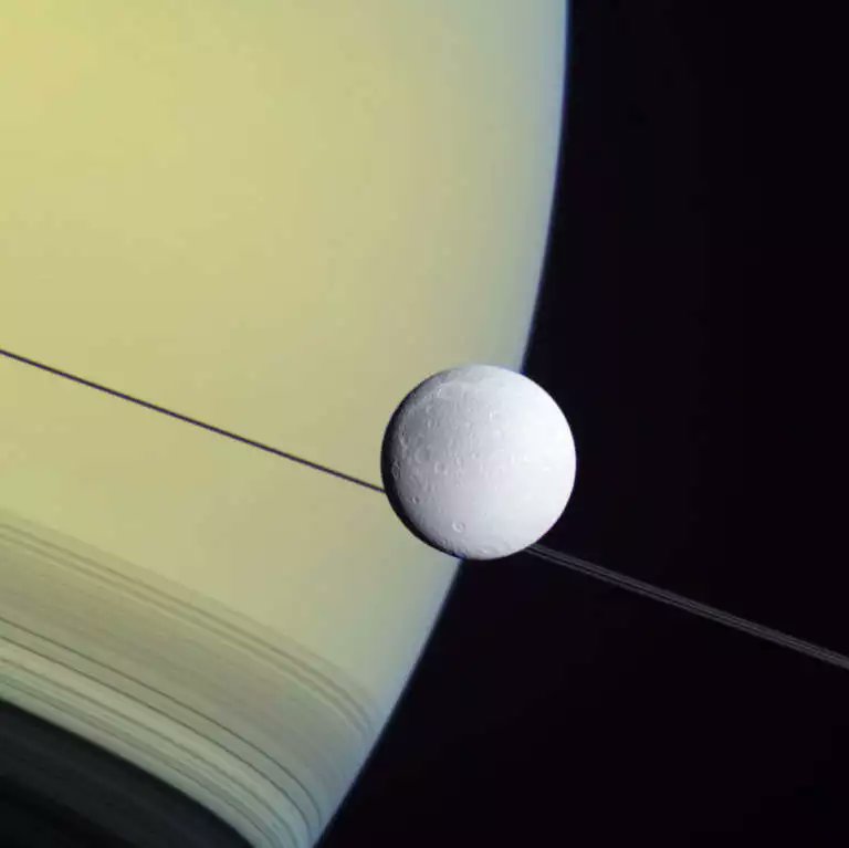 This wide-angle view of Dione poised over Saturn's limb, was taken by Cassini spacecraftexactly 12 years ago #Today