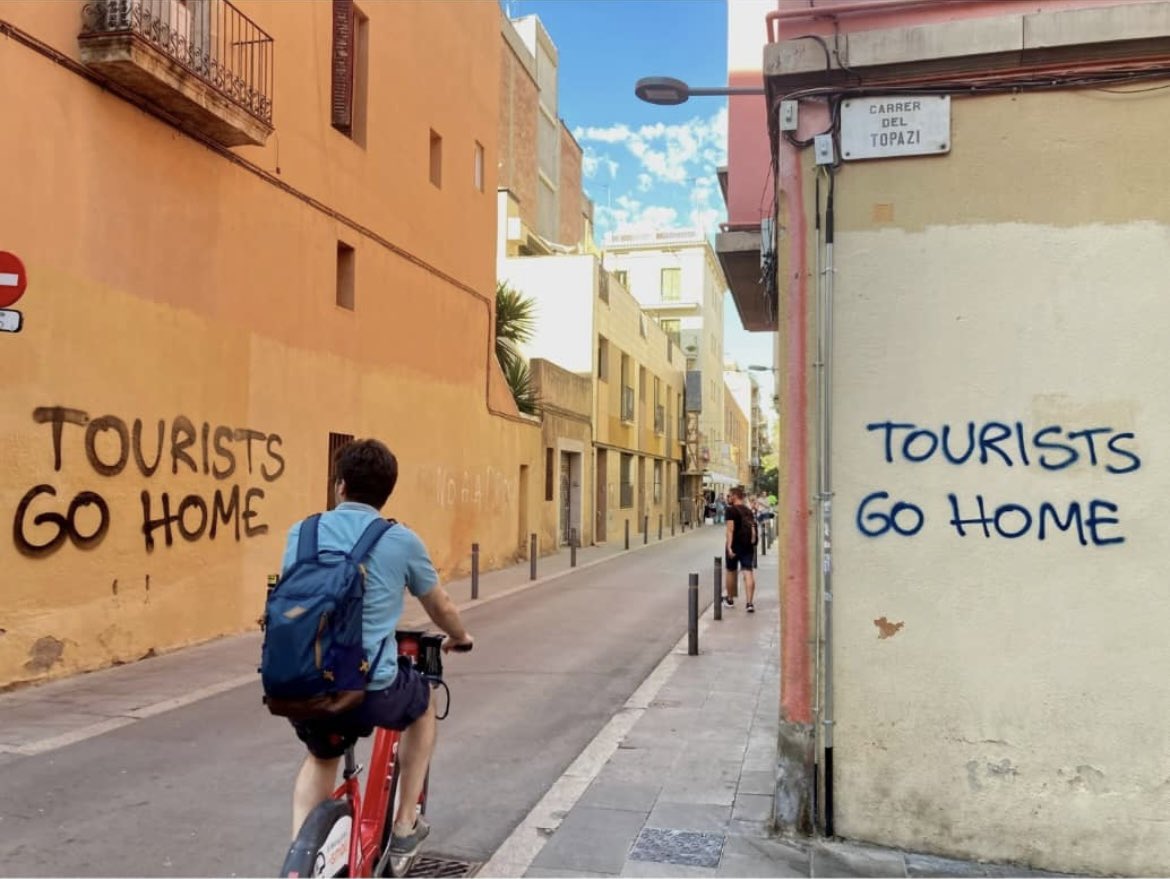 A message for visitors spray-painted on walls in Vila de Gràcia, an artists' quarter in Barcelona. While some nations court tourists, others weary of their presence. The Iridex model highlights the importance of sustainable tourism. 📸: Getty Images #SustianableTourism