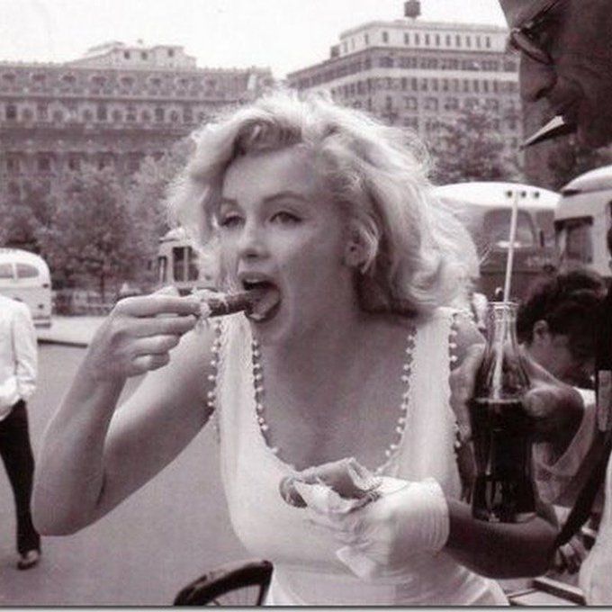 Candid photo of Marilyn Monroe eating a hot dog