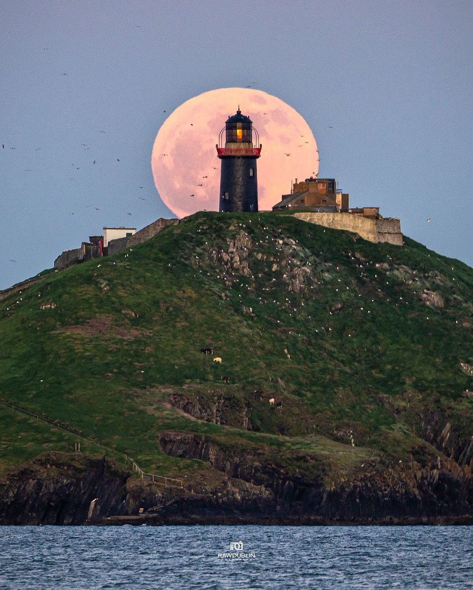 Pink Moon, rising brightly behind Ballycotton Lighthouse, Cork. The lighthouse is located on a hill overlooking the ocean, and it is a popular tourist destination. 

📸 insta@rawdublin