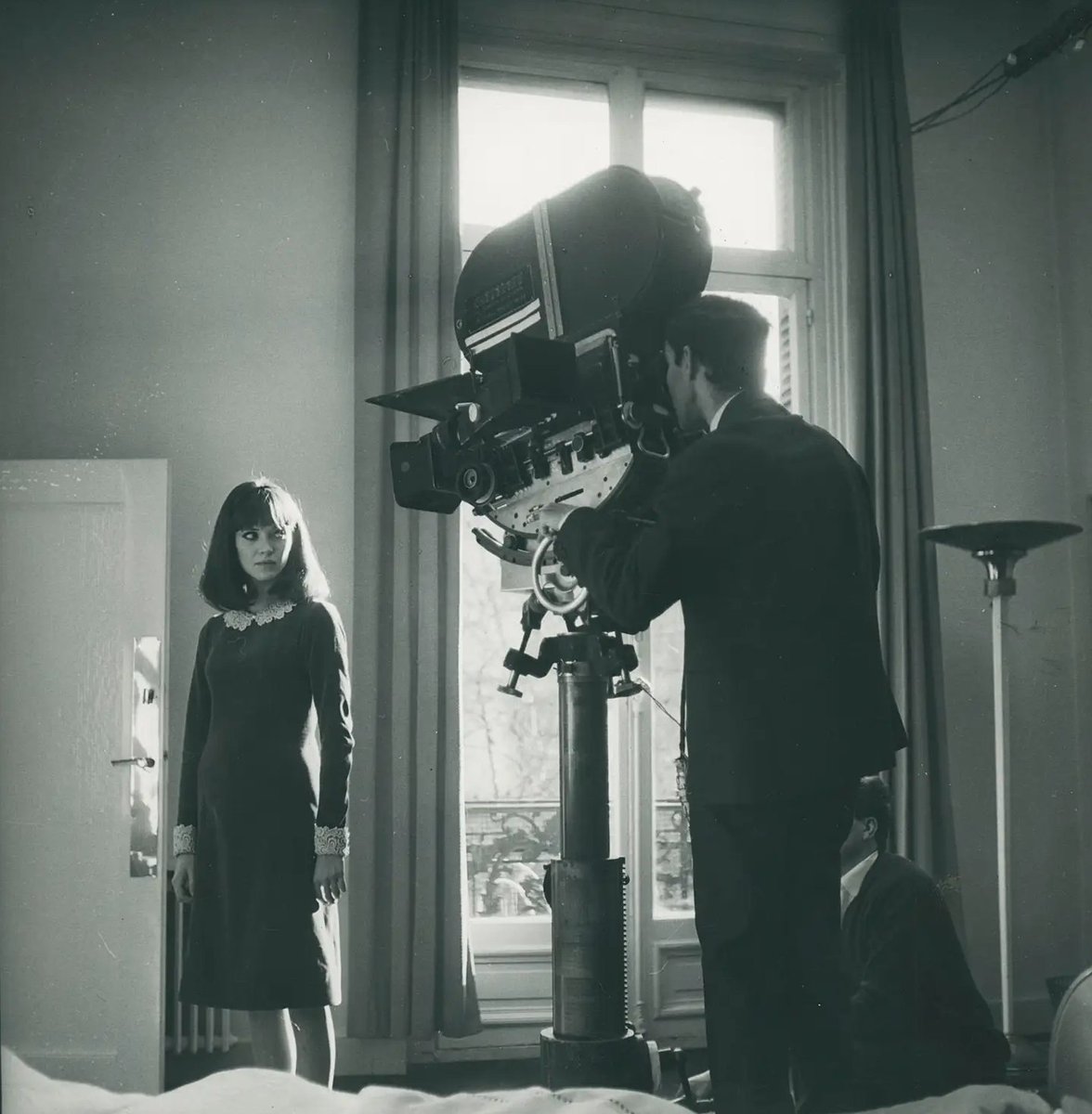 DP Raoul Coutard lining up a shot of Anna Karina while Godard looks on during the making of ALPHAVILLE (1965).