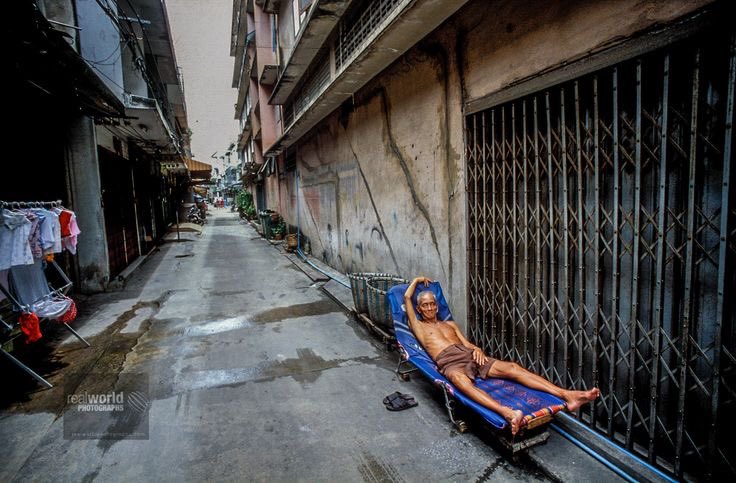 An aging Thai senior enjoys a nap and some peace. Bangkok, Thailand. Gary Moore photo. Real World Photographs. #thailand #bangkok #alley #man #city #nap #sweden #malmo #poverty #photojournalism #world #photography #garymoorephotography #denmark #realworldphotographs #nikon